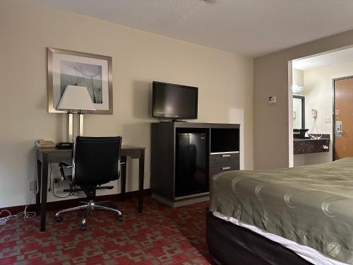 a hotel room with a bed and a desk and a television at Hotel Inn Milwaukee in Milwaukee