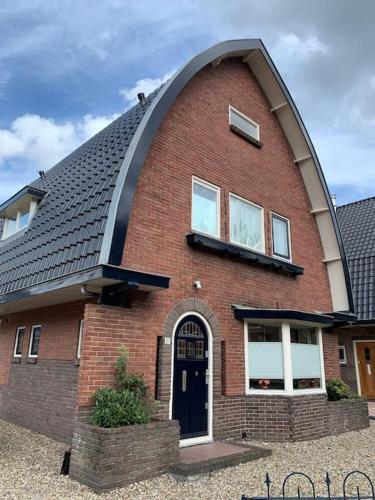 a large red brick house with a gambrel roof at Charming villa,central location,train and bus nearby in Soest