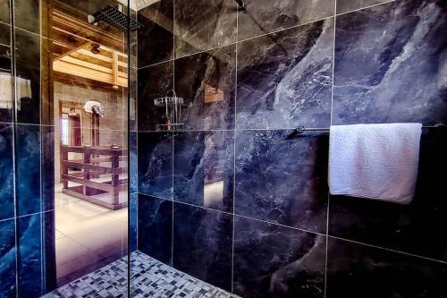 a bathroom with a shower with a marble tile wall at Ashburton Stays in Pietermaritzburg