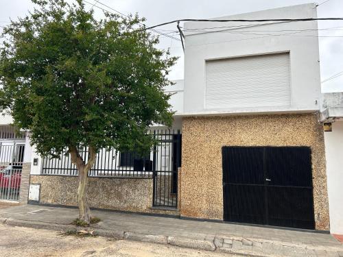 a tree in front of a building with a garage at La Casita de Salta 421 in Concordia