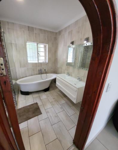 a large bathroom with a tub and a sink at honeymoon suite in Sandton