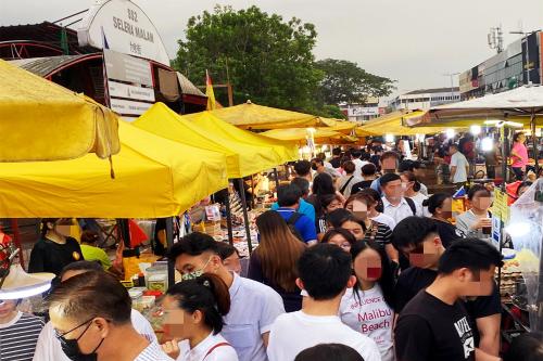 a crowd of people walking through a market with yellow umbrellas at 吉隆坡后花园别墅Backyard Garden Villa KL in Petaling Jaya