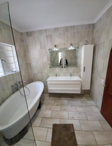 a bathroom with a tub and a sink and a bath tub at honeymoon suite in Sandton