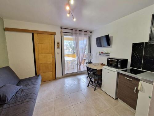 Il comprend un salon avec un lit et une cuisine avec une table. dans l'établissement Appartement T1 avec Terrasse, Parking, Proche Plage et Commodités - FR-1-387-207, à Marseillan