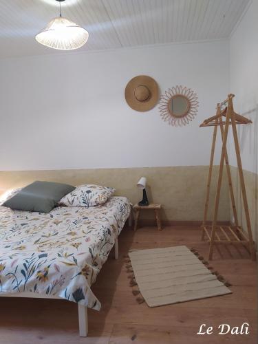 - une chambre avec un lit, un miroir et un tripode dans l'établissement Maison paisible Le Dali, à Piolenc