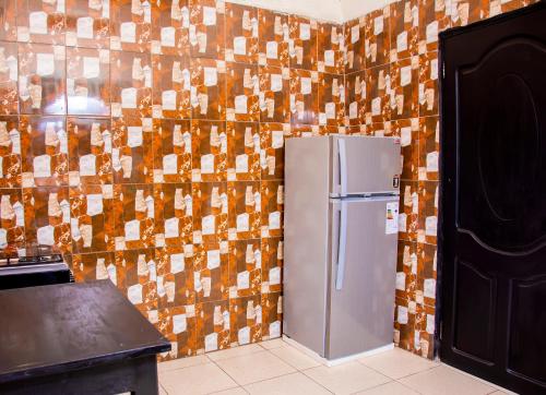 a refrigerator in a kitchen with a tiled wall at Ibuye Villa Holiday Home in Nyakinama