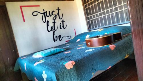 a bedroom with a blue bed with a sign on the wall at Bunnum Homestay in Ban Mae Tap
