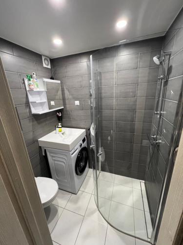 a bathroom with a shower and a washing machine at Valmiera City Centre Apartment in Valmiera