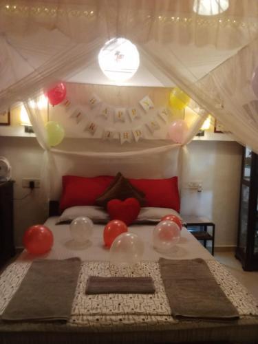 a bedroom with a bed with balloons on it at Hidden Haven - The Goan Getaway in Dhamni