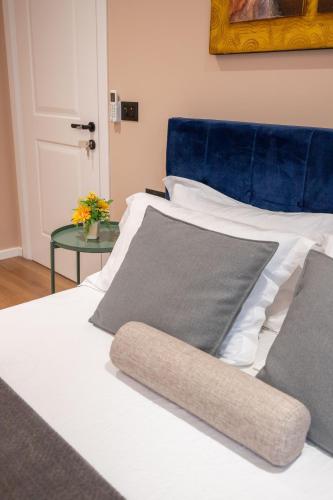 a white bed with a blue headboard and pillows at Garden lake City Center New Bazar Tirana in Tirana