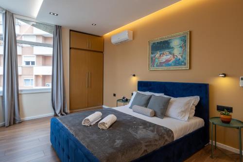 a bedroom with a blue bed with two towels on it at Garden lake City Center New Bazar Tirana in Tirana