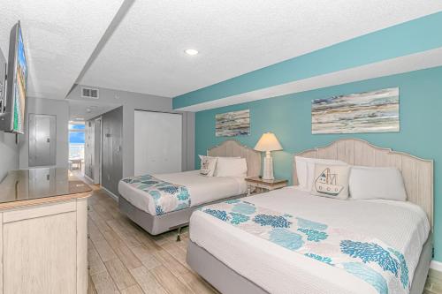 two beds in a room with blue walls at Atlantica 1055 in Myrtle Beach