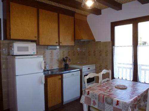 une cuisine avec un réfrigérateur blanc et une table dans l'établissement Appartement 3 chambres - Megeve, proche pistes de ski, parking, Wifi - FR-1-453-148, à Demi-Quartier