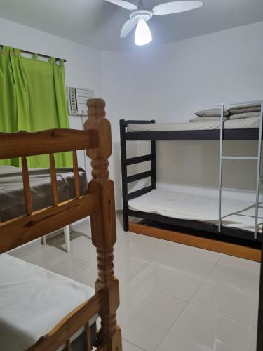 2 beliches num quarto com uma ventoinha em Apartamento Praia da Enseada no Guarujá