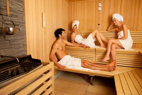 a group of three people sitting in a sauna at Perla, Resort & Entertainment in Nova Gorica
