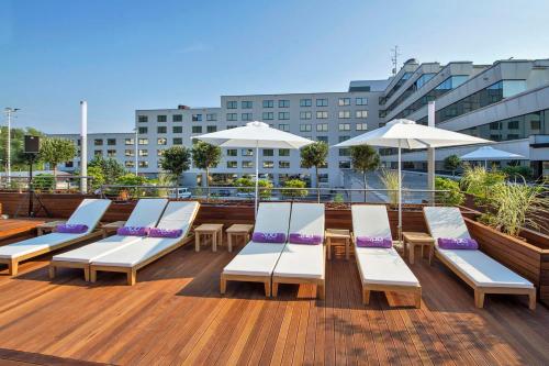 a row of lounge chairs and umbrellas on a deck at Perla, Resort & Entertainment in Nova Gorica