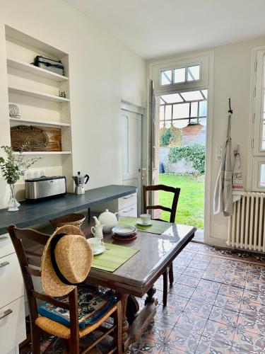 - une cuisine avec une table et des chaises en bois dans l'établissement VILLA LES ROSES Maison 5 Couchages, à Offranville