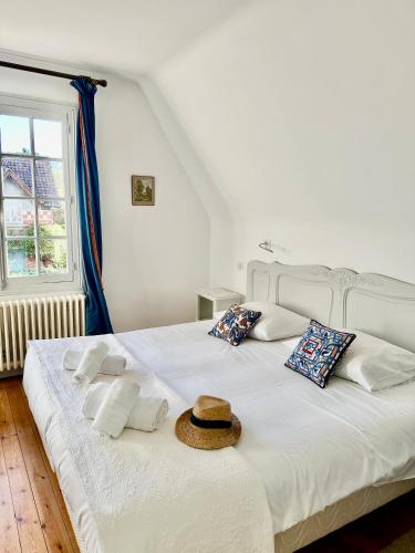 - un lit blanc avec un chapeau en haut dans l'établissement VILLA LES ROSES Maison 5 Couchages, à Offranville