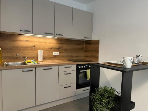 a kitchen with white cabinets and a black counter top at modernes Apartment in guter Lage in Ingolstadt