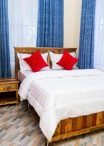 a bedroom with two beds with red pillows at VvEK B&B APARTMENT in Arusha