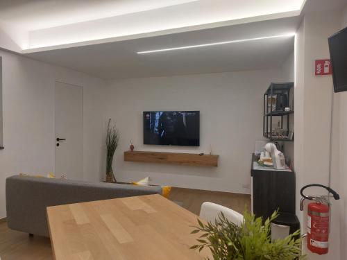 a living room with a couch and a television on a wall at GiglioApartment Etna Mare in Aci Castello