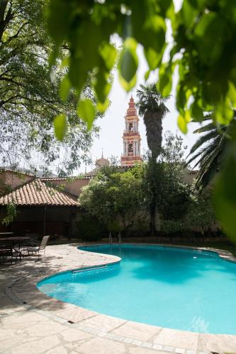 a swimming pool with a clock tower in the background at Hotel Salta in Salta