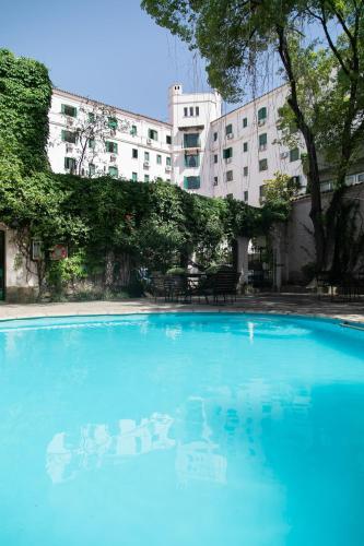 a large blue swimming pool in front of a building at Hotel Salta in Salta