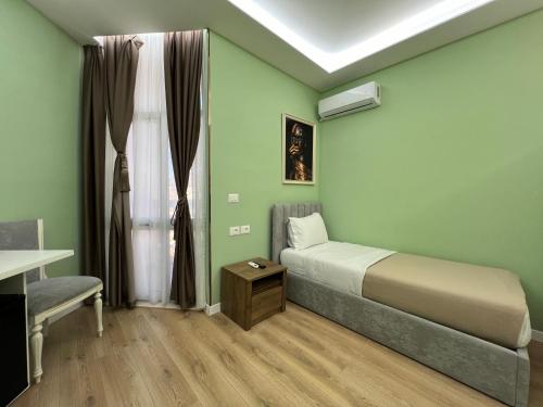 a bedroom with a bed and a desk and a window at Spiranca Luxury Suites in Tirana