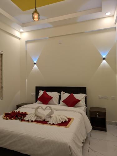 a bedroom with a large bed with red pillows at Regal Respite in Sultan Bathery