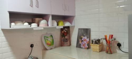 a kitchen counter with a shelf with dishes and utensils at YUYU B2 Honeymoon WiFi Genting highland in Genting Highlands