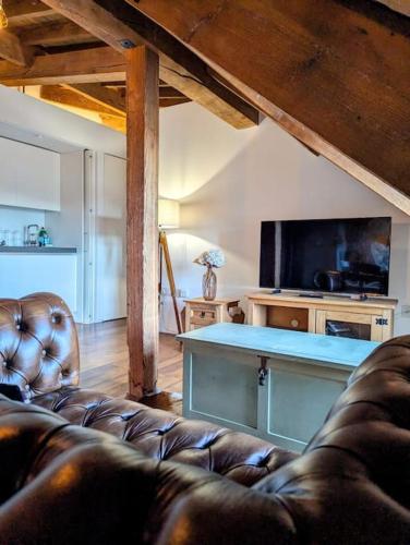 a living room with a leather couch and a television at Ocean City Royal Retreat in Plymouth