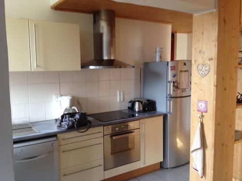 une cuisine avec une cuisinière et un réfrigérateur dans l'établissement Appart cosy et lumineux au cœur de Saint Gervais, à Saint-Gervais-les-Bains