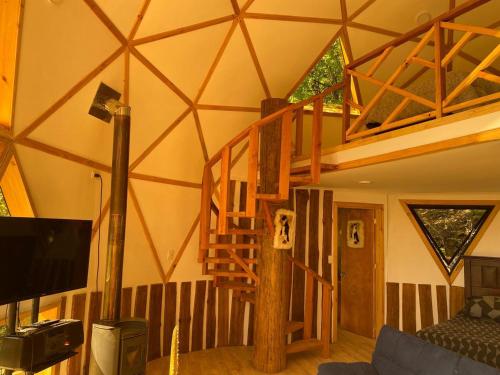 a living room with a spiral staircase in a house at Domos Mahuida in Las Trancas