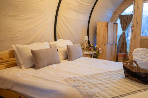 a bedroom with a white bed with a tent at Glamp In Style Pods Resort in Bran