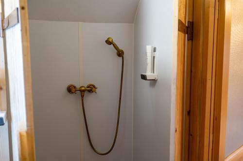a shower with a hose attached to a wall at Glamp In Style Pods Resort in Bran