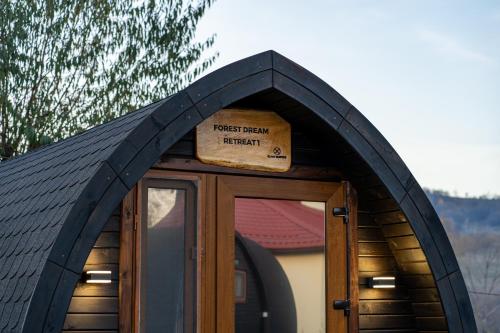 a wooden door with a sign on top of it at Glamp In Style Pods Resort in Bran