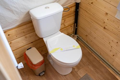 a small bathroom with a toilet in a room at Glamp In Style Pods Resort in Bran