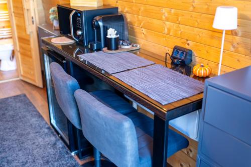 a table with blue chairs and a computer on it at Glamp In Style Pods Resort in Bran