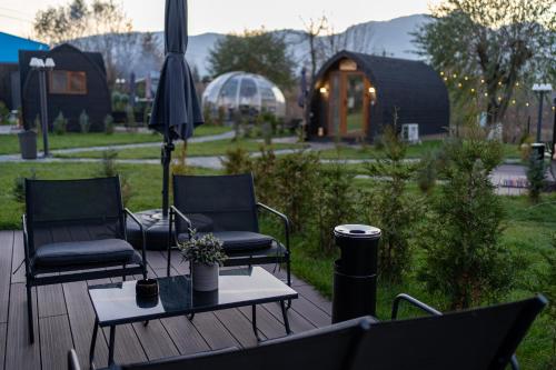 a deck with two chairs and a table and an umbrella at Glamp In Style Pods Resort in Bran