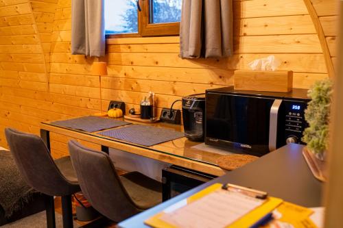 a kitchen with a counter with a microwave and a computer on it at Glamp In Style Pods Resort in Bran