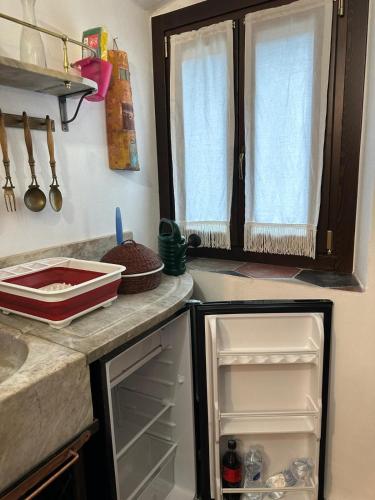 a kitchen with an open refrigerator and a window at ZuccarelloDreams in Zuccarrello