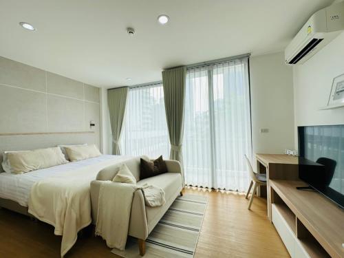 a bedroom with a bed and a couch and a television at 6th Avenue Sukhumvit BKK 308 BTS Asoke & Nana MRT Sukhumvit in Bang Kapi