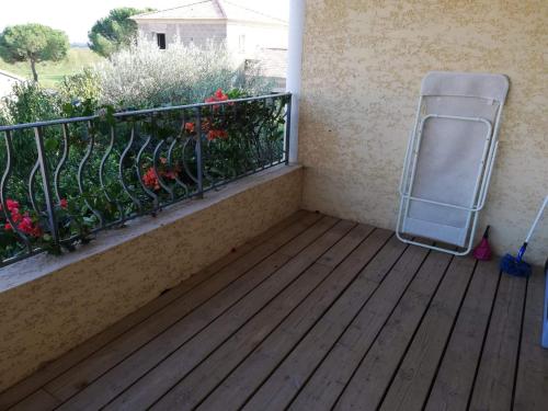 une chaise sur un balcon avec une clôture et des fleurs dans l'établissement Studio calme proche de la gare de Borgo, à Borgo