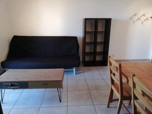 un salon avec un canapé et une table en bois dans l'établissement Studio calme proche de la gare de Borgo, à Borgo