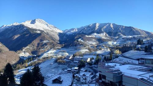 Oltre il ColleにあるDonizetti Apartment di Manenti Andreaの雪山を背景にした都市