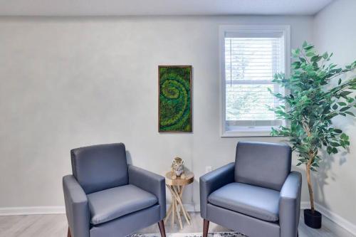 two blue chairs in a room with a window at Cozy Poconos Retreat Hot tub, Game room and igloo in Tobyhanna
