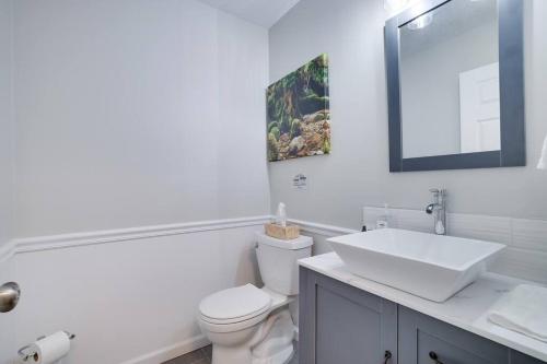 a white bathroom with a toilet and a sink at Cozy Poconos Retreat Hot tub, Game room and igloo in Tobyhanna