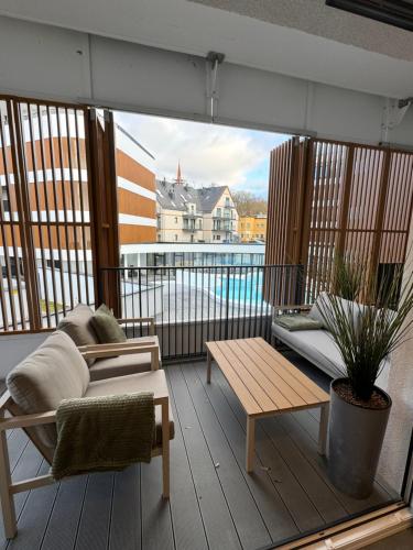 a balcony with a couch and a coffee table at Baltic Waves Resort Luksusowy apartamnet z basenem i parkingiem in Międzyzdroje