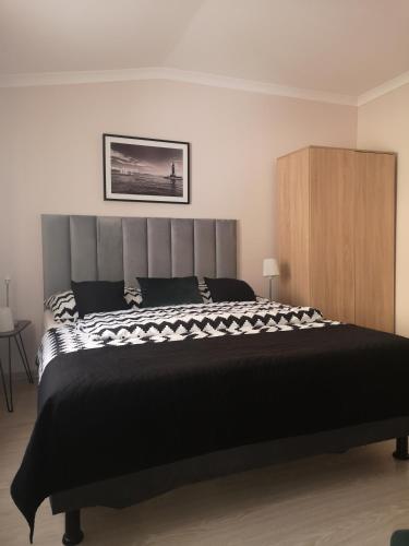 a bedroom with a large black and white bed at Villa Basia in Międzyzdroje