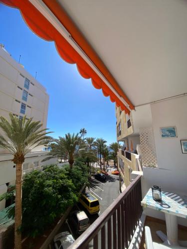 a balcony with a view of a parking lot with palm trees at Apartamento en Los Cristianos Edificio Guayero in Los Cristianos